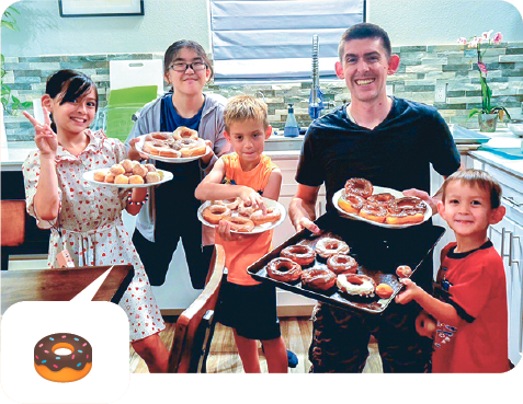 ホストファミリーと一緒にお皿に載ったたくさんのドーナツを持っている写真