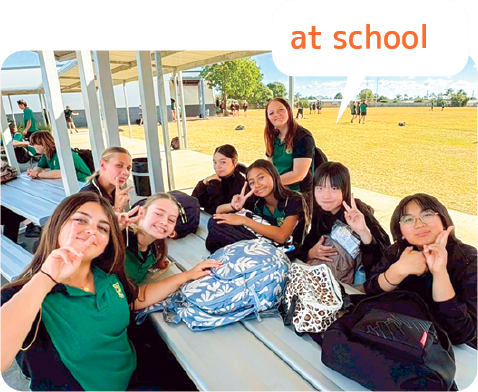 学校の外のテーブルで友だち達と記念写真