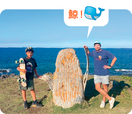 青い空、青い海、クジラのモニュメントを挟んでホストファーザーと写っている写真