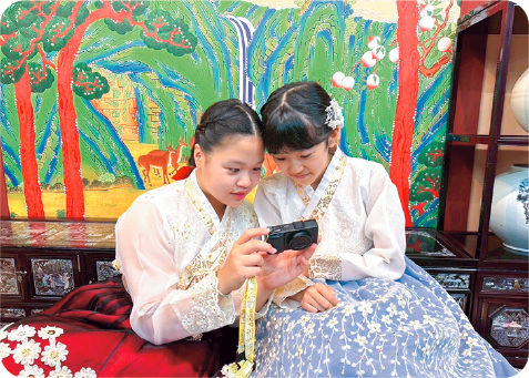 ホストと二人でチマチョゴリを着て、撮った写真を一緒に見ている写真